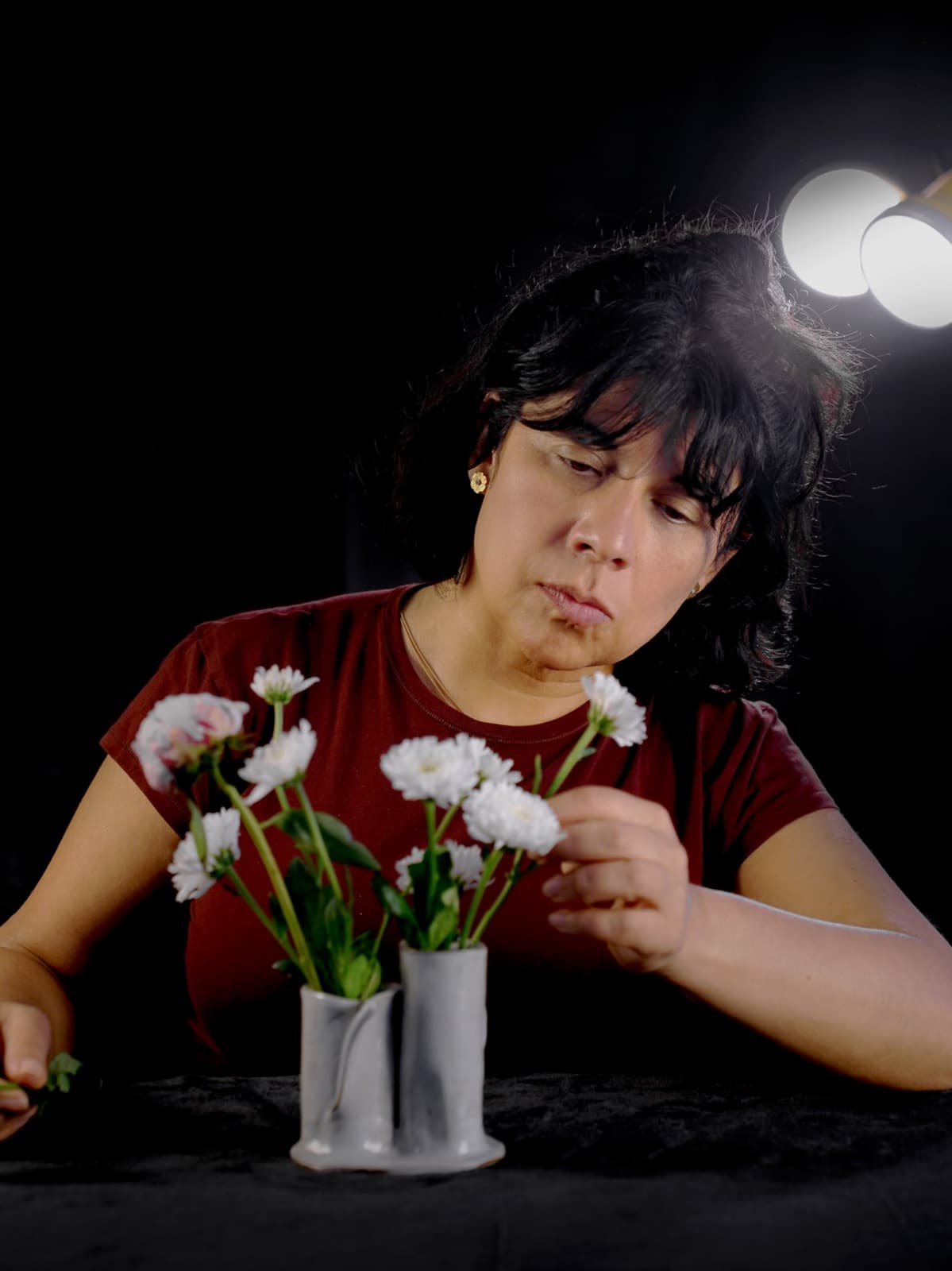 Eileen trabajando, colocando flores blancas en sus jarrones gemelos
